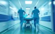 © Tida - A blurry motion image of a critical patient being swiftly transported on a stretcher by a team of medical professionals in a hospital hallway.