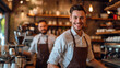 © MP Studio - two smiling men in a cafe, one in the foreground wearing a white shirt and leather apron