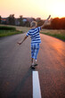 Cute baby boy running on the road at sunset. Happy childhood.
