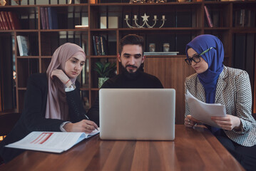 Wall Mural - Business team of a two Muslim woman and man working together in the office.