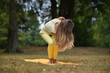 © Natalje Dietrich - A middle-aged woman is doing yoga in the park