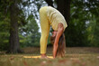 © Natalje Dietrich - A middle-aged woman is doing yoga in the park