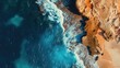 © Artyom - Top view of turquoise waves meeting the sandy shore