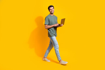 Aufkleber - Full length photo of good mood funky guy wear khaki t-shirt walking communicating modern device isolated yellow color background