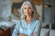© Konstiantyn Zap - Confident maturity: A poised and content mature woman exudes confidence in her neatly styled gray hair and professional attire.