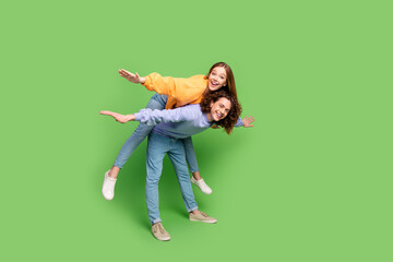 Sticker - Full size profile photo of two crazy positive people piggyback arms wings empty space isolated on green color background