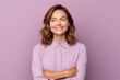 © Inigo - Portrait of smiling young woman with crossed arms over violet background.