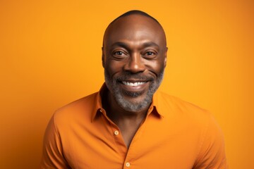 Wall Mural - Portrait of a smiling african american man in orange shirt on orange background