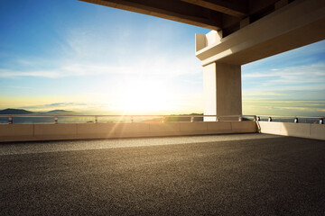 Modern highway road under the overpass with sunset sky.