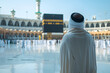 Man in pilgrim performing haj or umrah in front of kaaba, mecca. Religious pilgrimage and worship in Islam.