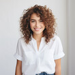 © Endra - human face expression a potrait of a caucasian latina young woman with curly hair wearing white shirt smiling in front of the camera on white background AI Generate