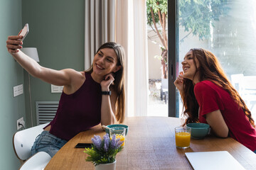 Happy friends taking selfie with mobile smartphone while lunching at home - Young trendy woman having fun eating together - Youth lifestyle food culture concept