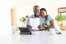 African American couple reviews finances at home, with copy space