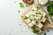 Vegan tofu food on cutting board white tabletop top down view empty space
