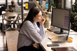 © Wavebreak Media - Young Caucasian woman works at her casual business office desk, with copy space