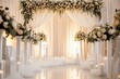 Floral decorated white wedding arch indoors with large white candles