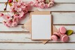 
card, blank white greeting card in frame made of pink magnolia flowers and marshmallows on white wooden background. flat lay. top view. mock up. wedding or womens day composition
