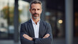 © Shanorsila - Smiling middle aged male businessman standing with crossed arms, looking at camera.
