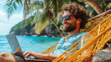 a man is working on a laptop while lying in a hammock by the ocean, showcasing a remote work lifesty