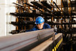 © GALDRIC - Focused man working pushing steel beam in warehouse
