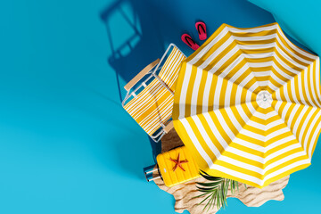 Wall Mural - Yellow beach chair and umbrella with summer accessories on blue background with copy space. 3D Rendering, 3D Illustration