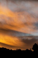 Sticker - Vibrant cloudy sky at sunset over a town.