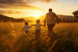 Fototapeta  - Happy family with two children holding hands of each other and running through wheat field at sunset