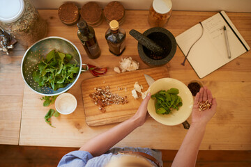 Poster - Cooking, person hands and salad in a home with diet, nutrition and healthy food from above. Kitchen, bowl and leaves for organic and vegan lunch with nuts and wood board in a house with wellness