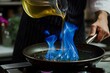 chef pouring oil into a frypan, causing blue flames to dance