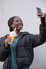 Wall Mural - Young woman taking selfie while holding bubble tea