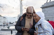 UK, London, Young female tourists in hijabs using phone in Trafalgar Square
