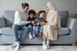 © Cultura Creative - Parents and sons (2-3, 6-7) relaxing on sofa