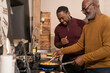 © Cultura Creative - Two men preparing food in kitchen