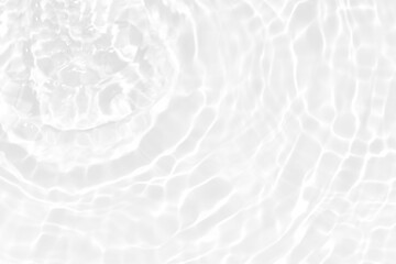 White water with ripples on the surface. Defocus blurred transparent white colored clear calm water surface texture with splashes and bubbles. Water waves with shining pattern texture background.