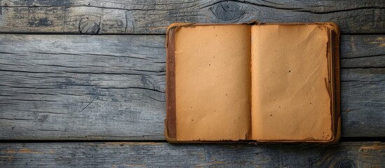 Wall Mural - Brown diary book placed on a wooden background with empty space on the right page.