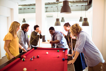Canvas Print - Diverse young people playing billiard in the office