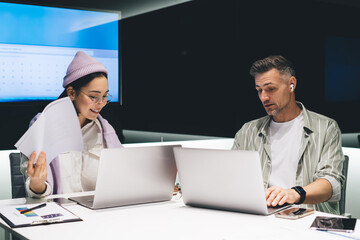 Fototapete - Professional employees with digital laptops making informative research on website, skilled male and female financial experts in smart casual clothes browsing business page via application on netbooks