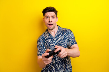 Canvas Print - Photo of speechless impressed man hold controller nervous play video games isolated on yellow color background