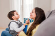 © Renata Hamuda - side view of Mother and toddler Son Sharing a funny Conversation on a Comfortable Living Room Couch