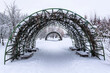 Arch made of metal rods  for climbing plants in a city park in winter