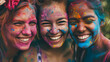 Three Happy multiracial girlfriends with colorful faces celebrating Holi festival of colors