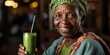 African woman drinking green herbal smoothie, healthy eating theme