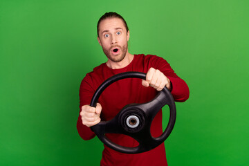 Poster - Portrait of astonished guy with bristle wear red sweatshirt hold steering wheel staring at accident isolated on green color background