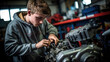 © David - Young car mechanic apprentice. Dark garage, fixing engine, Youth employment