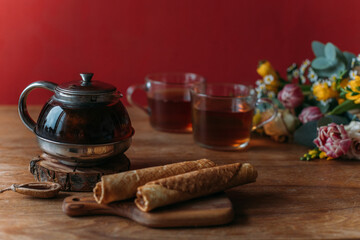 Wall Mural - Still life. A table with a teapot, mugs and flowers