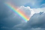 Fototapeta Tęcza - A cloudy sky featuring a rainbow
