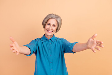 Sticker - Photo of kind candid sincere woman with bob hairstyle dressed blue shirt stretching arms to hug you isolated on beige color background