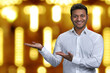 © DenisProduction.com - Handsome businessman looking at camera while presenting something on golden bokeh background. Winter holiday special offer.
