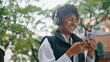 © stockbusters - Cheerful lady listening music by wireless headphones holding phone close up.