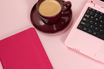 Wall Mural - Workplace, coffee with laptop set on pink background,Modern office desk workspace with coffee cup, notebook, laptop on pink background